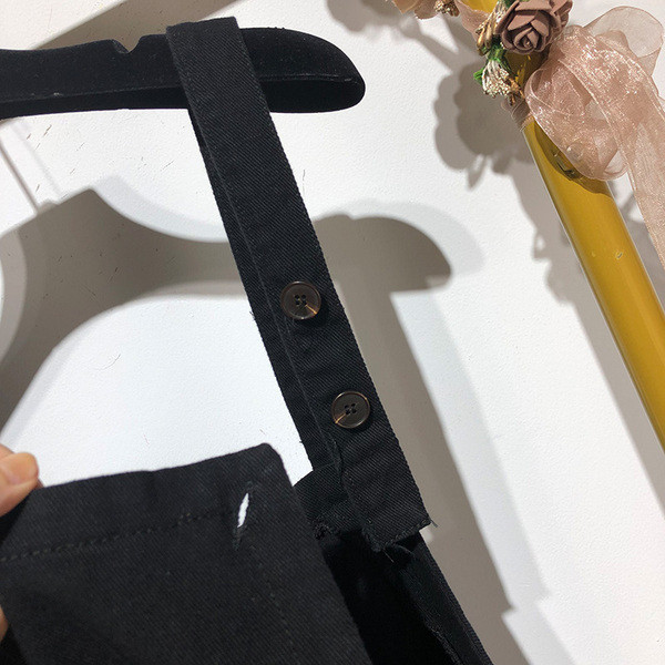 Salopetă scurtă cu bretele subțiri și nasturi de culoare neagră