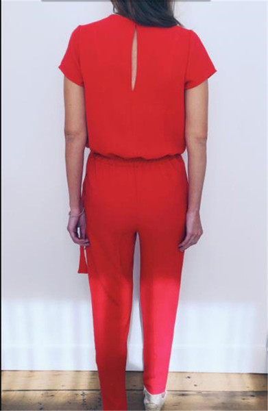 Modern női overall mély nyakkivágással és rövid ujjú piros színben