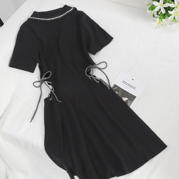 Modern női ruha kivágásokkal és nyakkendőkkel fekete színben