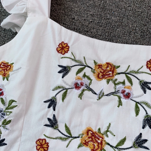 Modern, rövid női felső, hímzéssel és vastag pántokkal