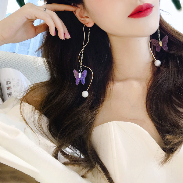 Arany színű női fülbevaló gyöngyökkel