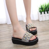 Modern női papucs kövekkel két színben egy emelvényen