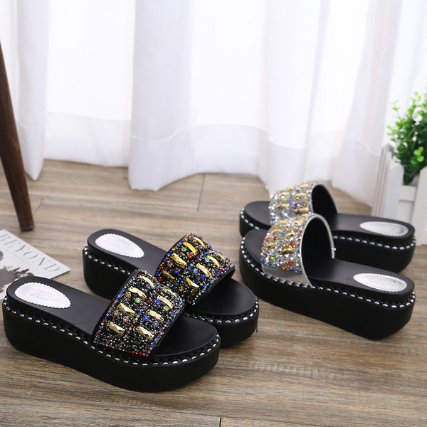 Modern női papucs kövekkel két színben egy emelvényen