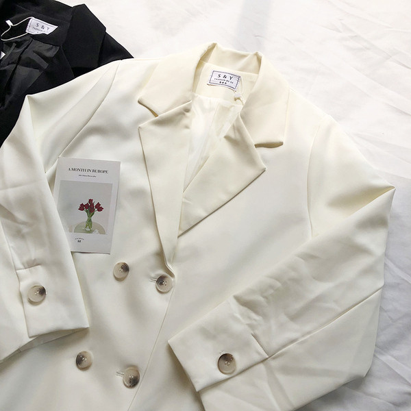 Stílusos női kabát dupla rögzítéssel, fekete-fehér színben