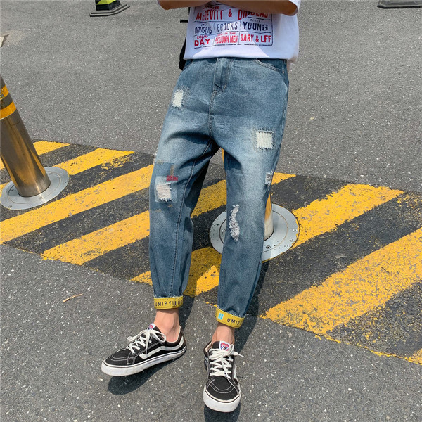 Modern férfi farmer, szakadt motívumokkal és kék színű feliratokkal