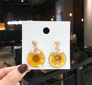 Fehér és sárga női fülbevaló gyöngyökkel