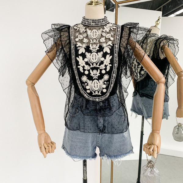 Stílusos női felső, fehér és fekete hímzéssel