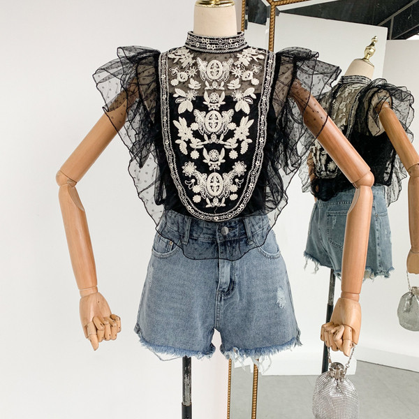 Stílusos női felső, fehér és fekete hímzéssel