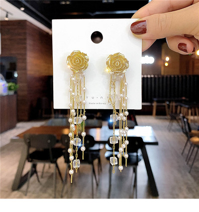 Arany színű női fülbevaló gyöngyökkel és gyöngyökkel