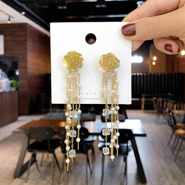 Arany színű női fülbevaló gyöngyökkel és gyöngyökkel