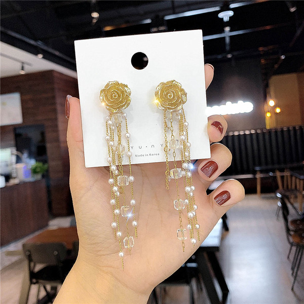 Arany színű női fülbevaló gyöngyökkel és gyöngyökkel