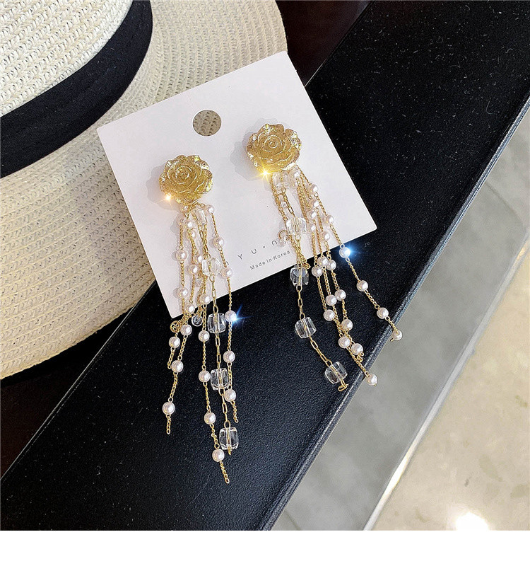 Arany színű női fülbevaló gyöngyökkel és gyöngyökkel