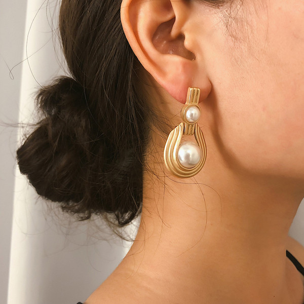 Elegáns női fülbevaló gyöngyökkel, arany színben