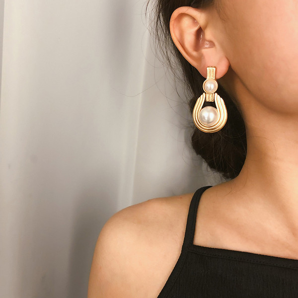 Elegáns női fülbevaló gyöngyökkel, arany színben