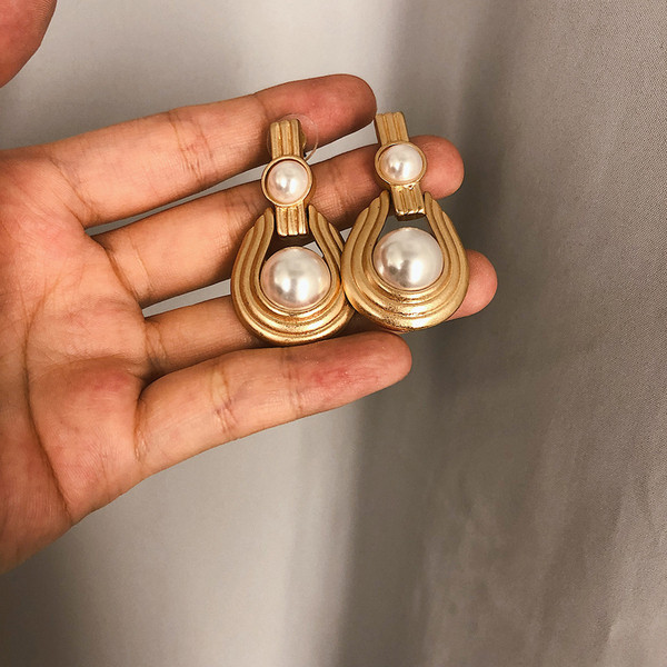 Elegáns női fülbevaló gyöngyökkel, arany színben