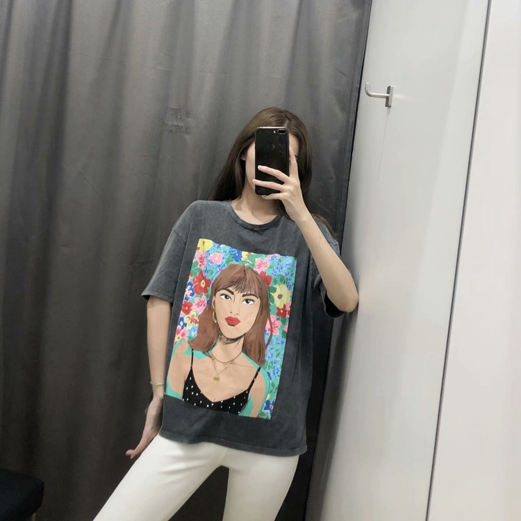 Szürke színű, rátéttel ellátott, rövid ujjú női póló