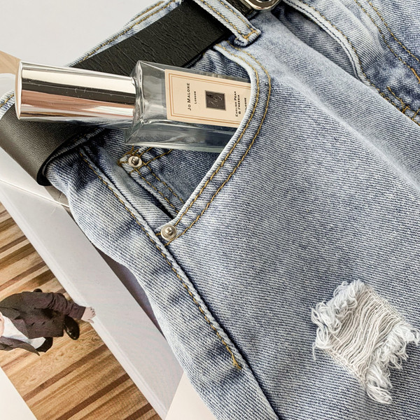 Modern női farmerszoknya szakadt motívumokkal