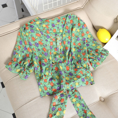 Hétköznapi női blúz szalaggal és virágos motívummal