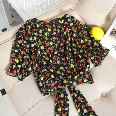 Hétköznapi női blúz szalaggal és virágos motívummal