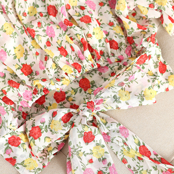 Hétköznapi női blúz szalaggal és virágos motívummal