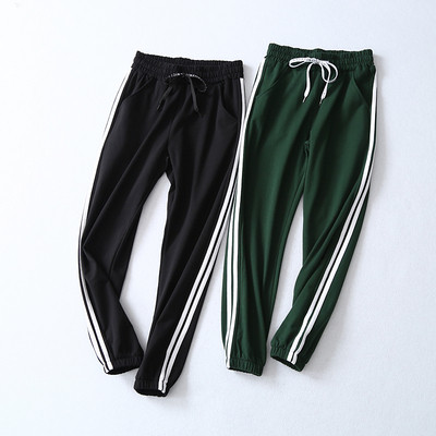 дамски спортни панталони в черен и зелен цвят с страничен кант