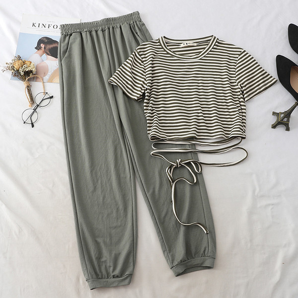 Κομψό και μοντέρνο γυναικείο σετπου περιλαμβάνει ένα ριγωτό μπλουζάκι με κορδόνια  και παντελόνι σε δύο χρώματα