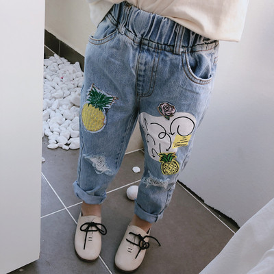 Modern children`s jeans for girls with torn motifs and applications