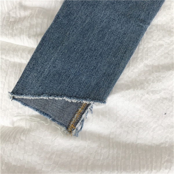 Lezser női farmer szakadt motívumokkal, világos színben