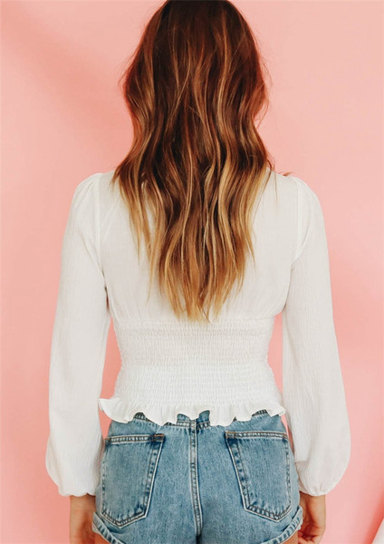 Modern női blúz hosszú ujjal és mély nyakkivágással, fehér színben