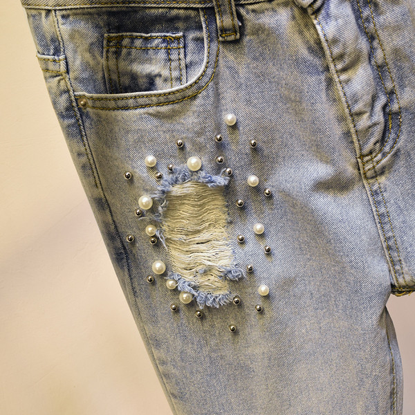 Aktuális női farmer szakadt motívumokkal, díszítőgyöngyökkel