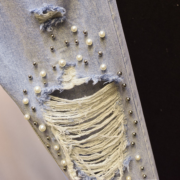 Aktuális női farmer szakadt motívumokkal, díszítőgyöngyökkel