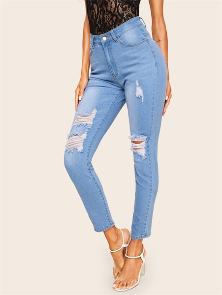 Modern női hosszú farmer, kék színű szakadt motívumokkal