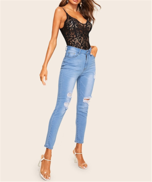 Modern női hosszú farmer, kék színű szakadt motívumokkal