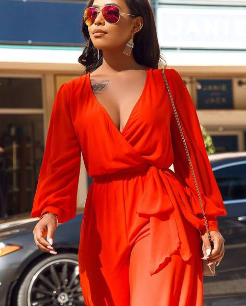 Salopetă de damă elegantă, cu decolteu adânc și mâneci lungi, de culoare portocalie