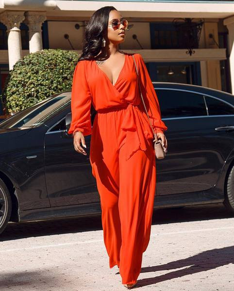 Salopetă de damă elegantă, cu decolteu adânc și mâneci lungi, de culoare portocalie