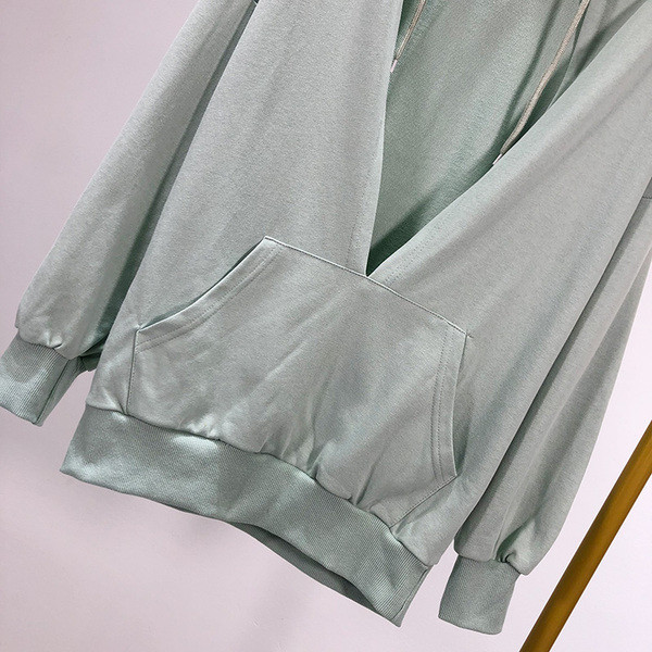 Zöld színű női pulóver kapucnival és nyakkendővel