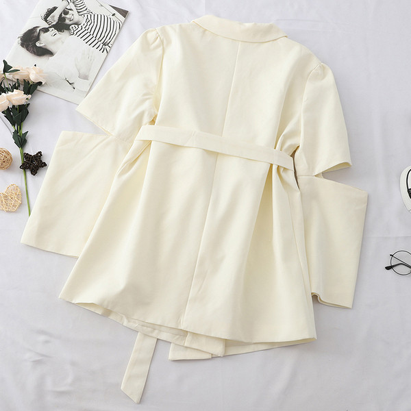 Modern női kabát kivágott részekkel és övvel fekete-fehér színben