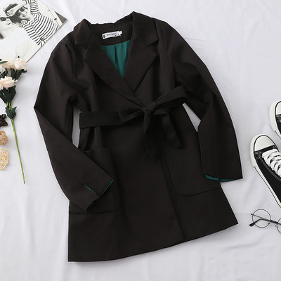 Stílusos női kabát fekete-fehér övvel és zsebekkel