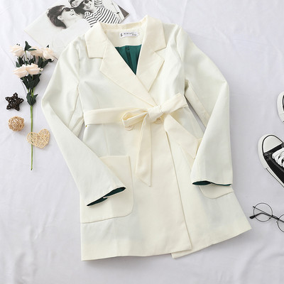 Stílusos női kabát fekete-fehér övvel és zsebekkel