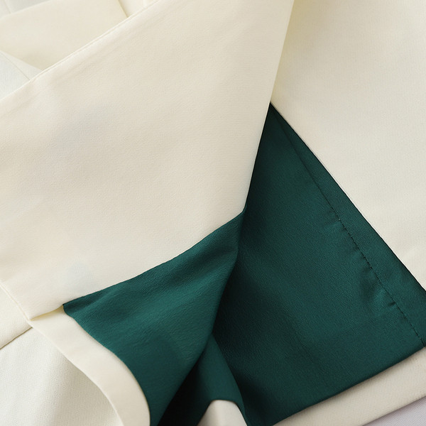 Stílusos női kabát fekete-fehér övvel és zsebekkel