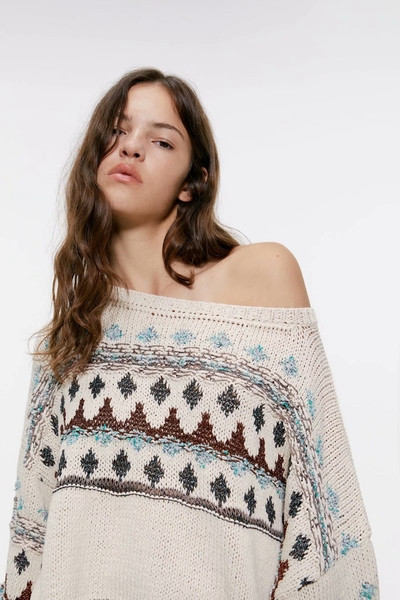 Rövid, bézs színű, hosszú ujjú pulóver mintával