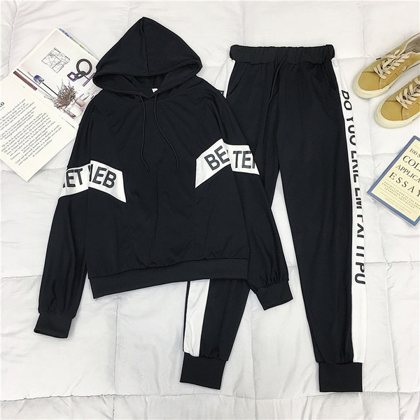 Echipa sportivă feminină care include un hanorac cu glugă și pantaloni alb-negru