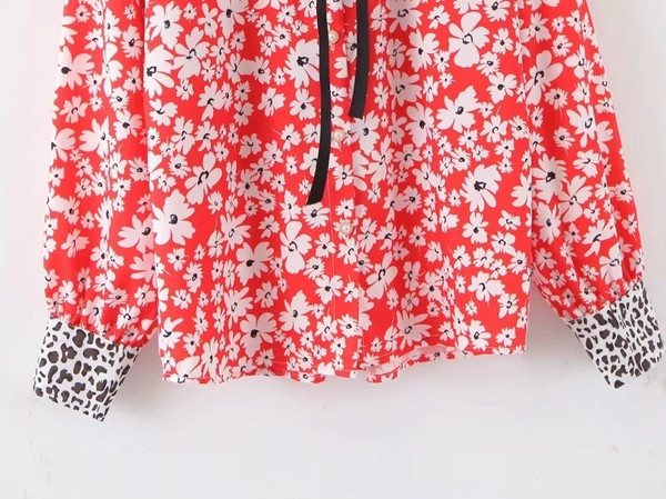 Ένα μοντέρνο γυναικείο πουκάμισο με μοτίβα λουλουδιών και κλασικό γιακά σε κοκκινο χρώμα