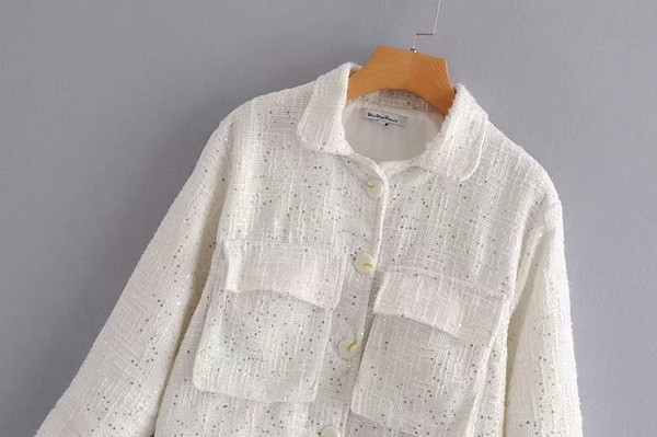 Modern női kabát flitterekkel és fekete-fehér zsebekkel