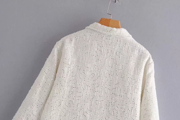 Modern női kabát flitterekkel és fekete-fehér zsebekkel