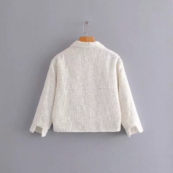 Modern női kabát flitterekkel és fekete-fehér zsebekkel