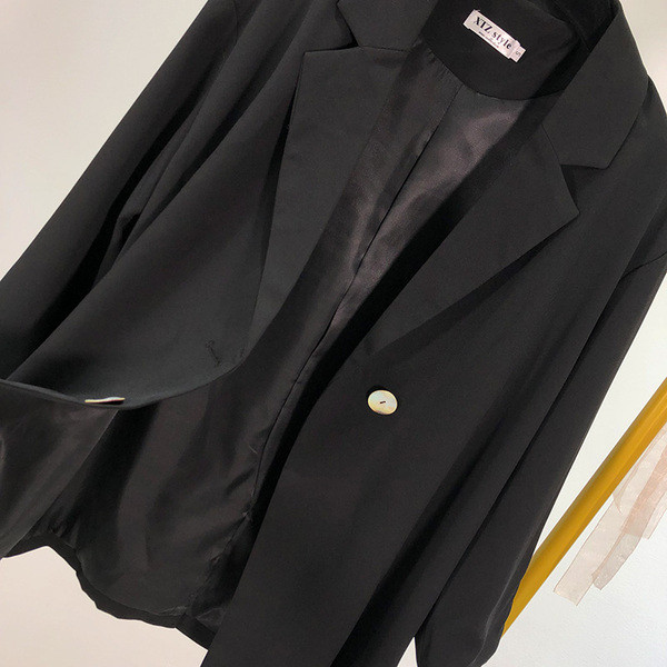 Női kabát aszimmetrikus rögzítéssel, fekete színben