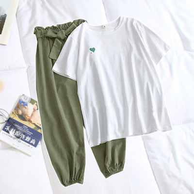 Női alkalmi szett, amely tartalmaz egy fehér pólót hímzéssel és zöld, magas derekú nadrágot