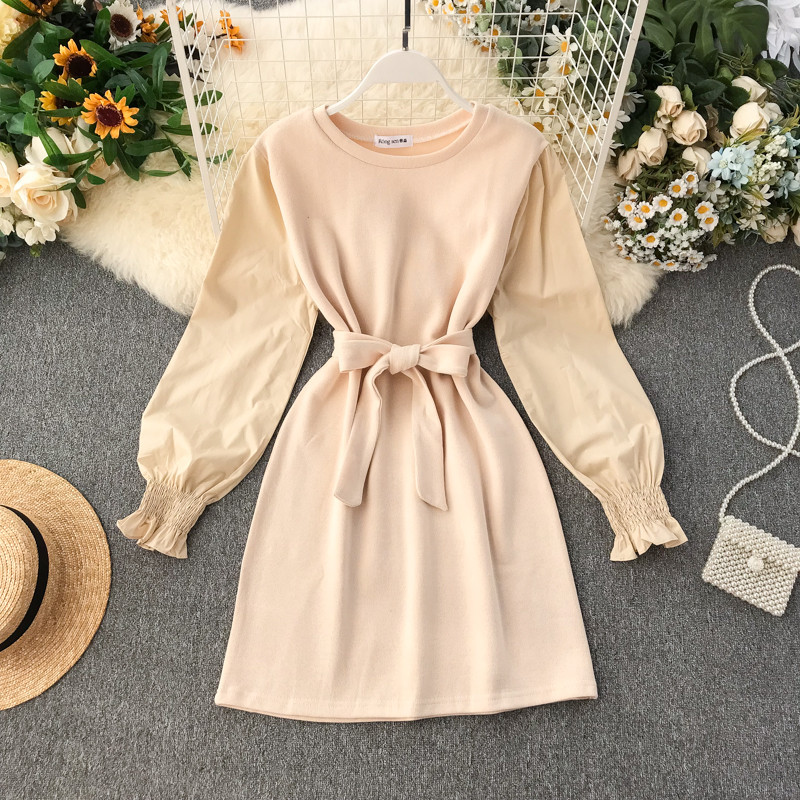 Ένα κομψό γυναικείο φόρεμα με κορδέλα και μακρύ μανίκι