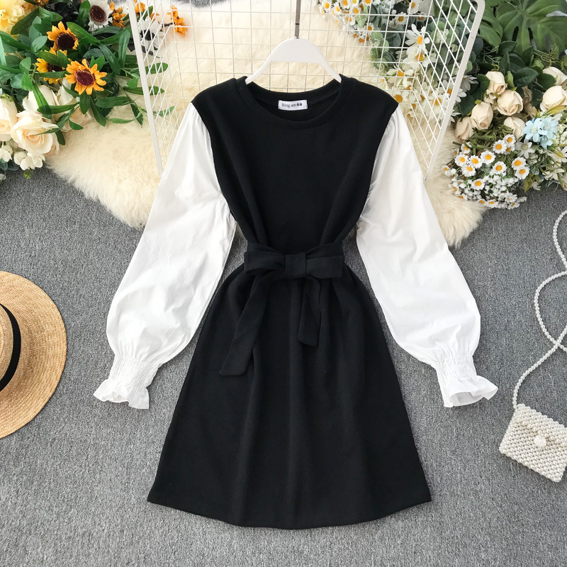 Ένα κομψό γυναικείο φόρεμα με κορδέλα και μακρύ μανίκι